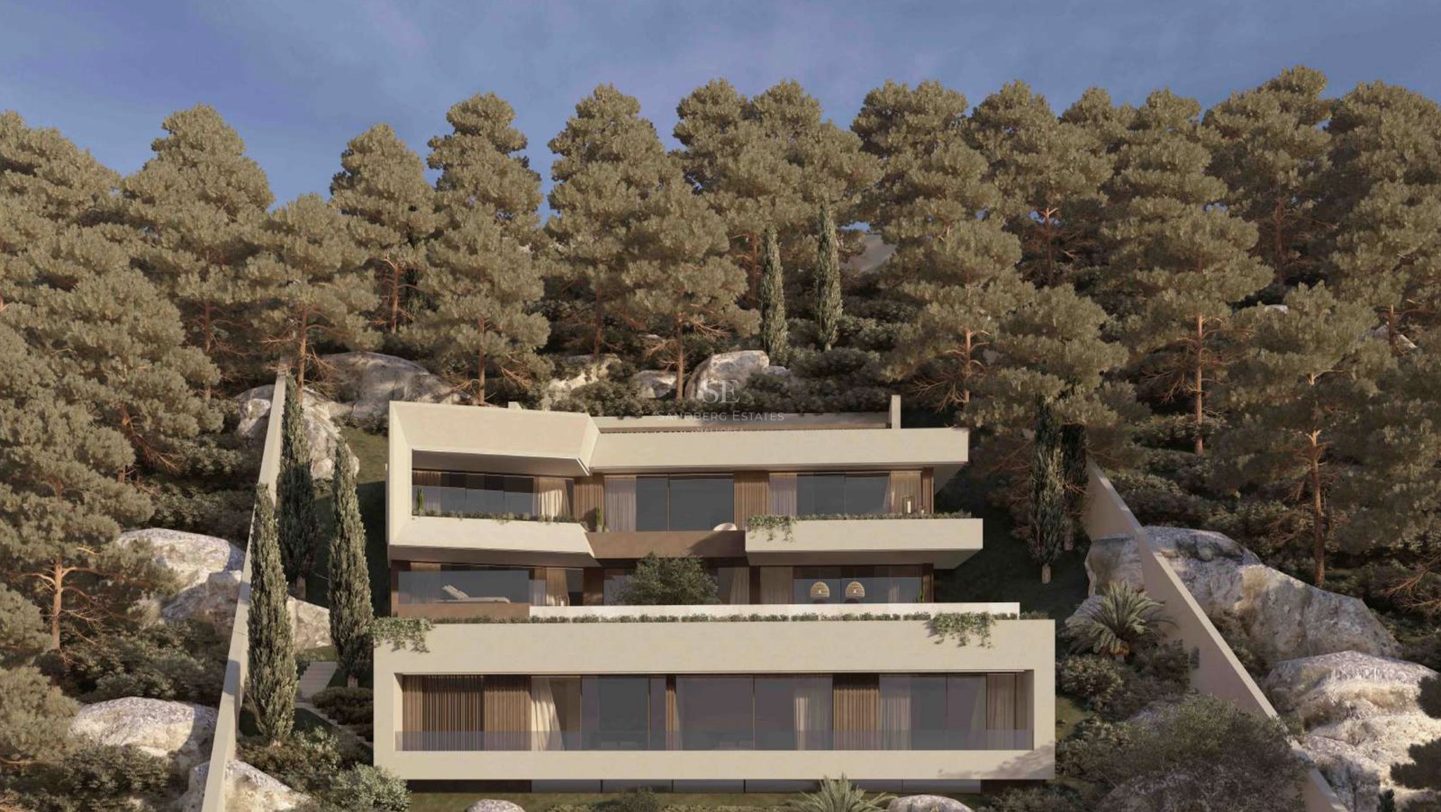 Villa contemporánea de tres niveles con terrazas blancas en una ladera empinada rodeada de pinos y rocas.