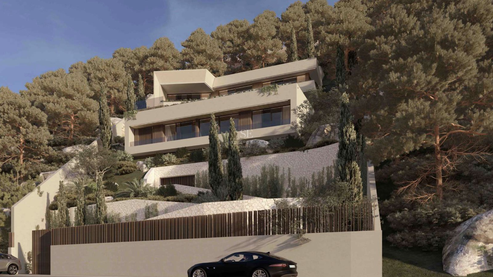 Villa contemporánea de varios niveles construida en una ladera boscosa con muros de piedra natural.