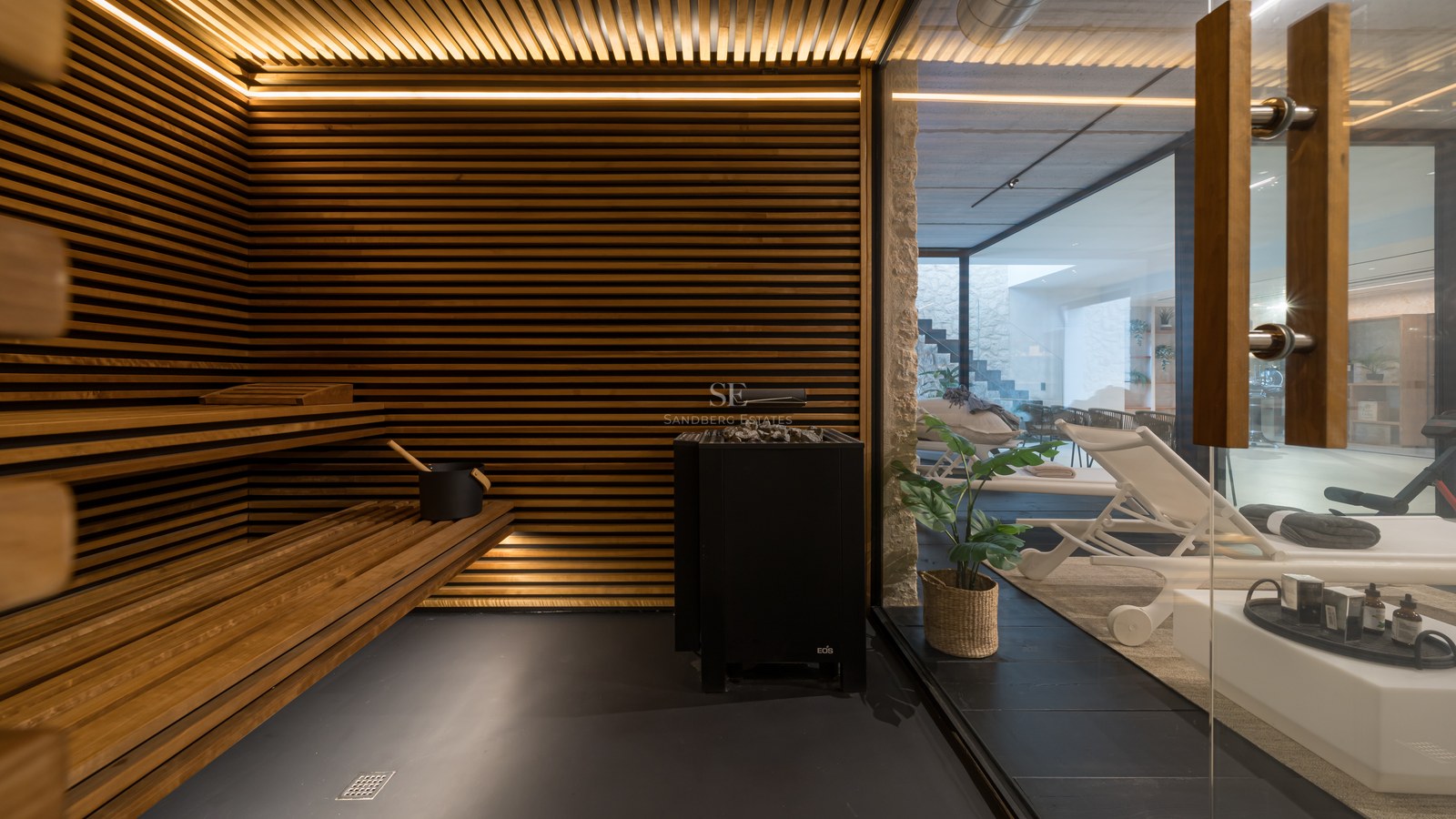 Intérieur d'un sauna de luxe avec lattes de bois horizontales, éclairage LED intégré et vue sur l'espace détente.