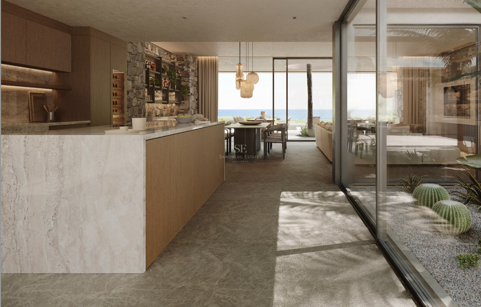 Cuisine moderne avec îlot en marbre, murs en pierre et baies vitrées donnant sur la mer Méditerranée.