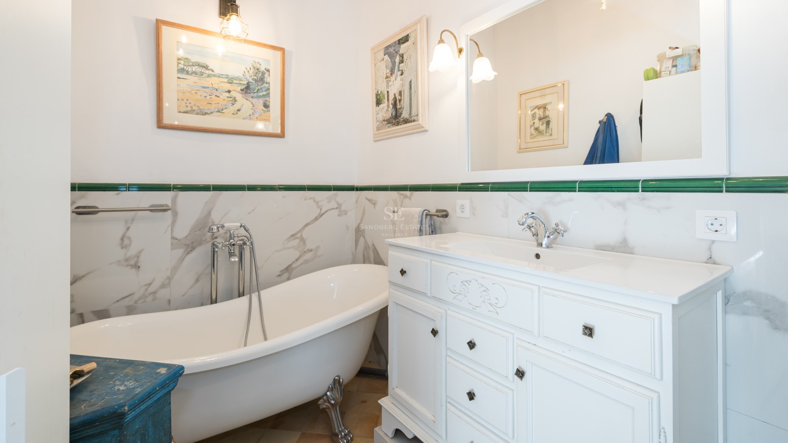 Salle de bain traditionnelle avec baignoire sur pieds, meuble vasque blanc et accents de carrelage vert.