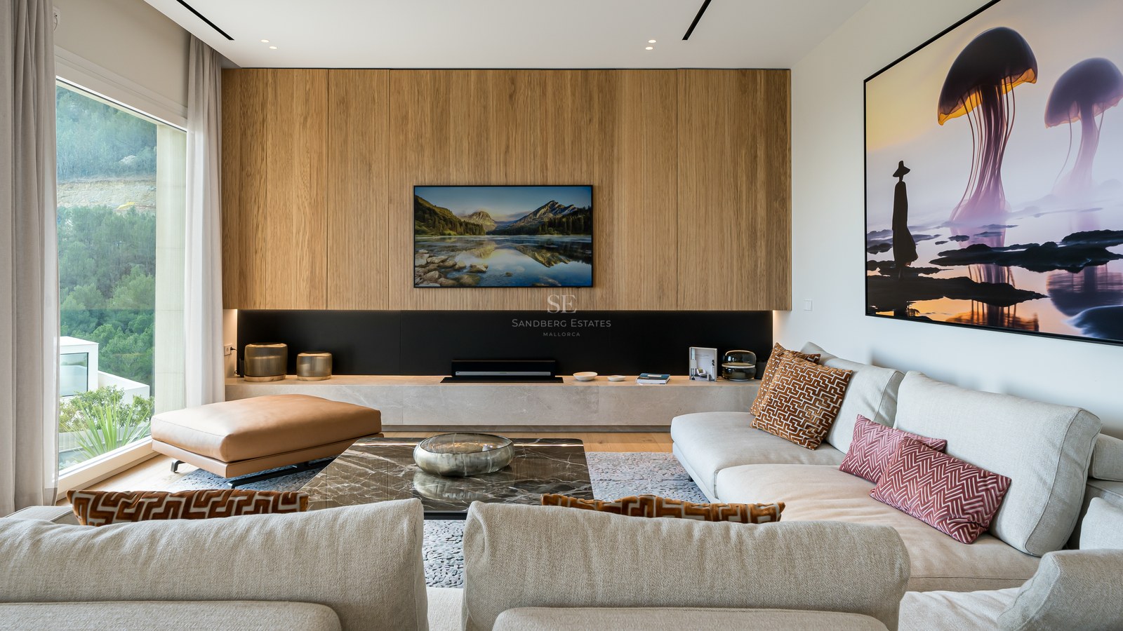 Salón moderno con pared de listones de madera, televisión integrada y ventanales con vistas a la naturaleza.