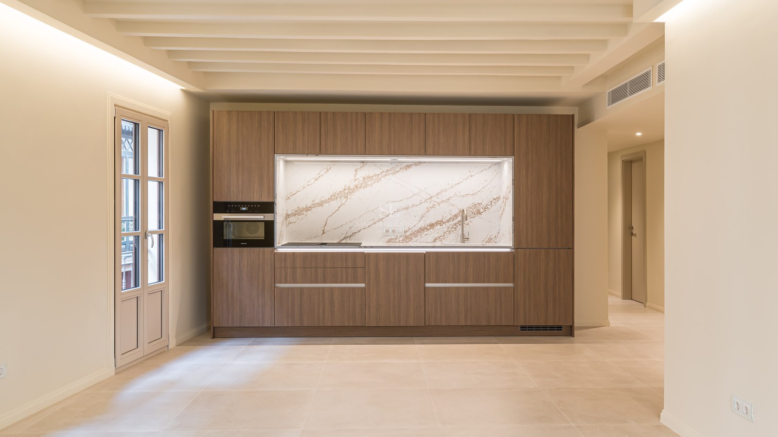 Cocina contemporánea con armarios de madera de nogal, frontal de mármol veteado y electrodomésticos integrados.