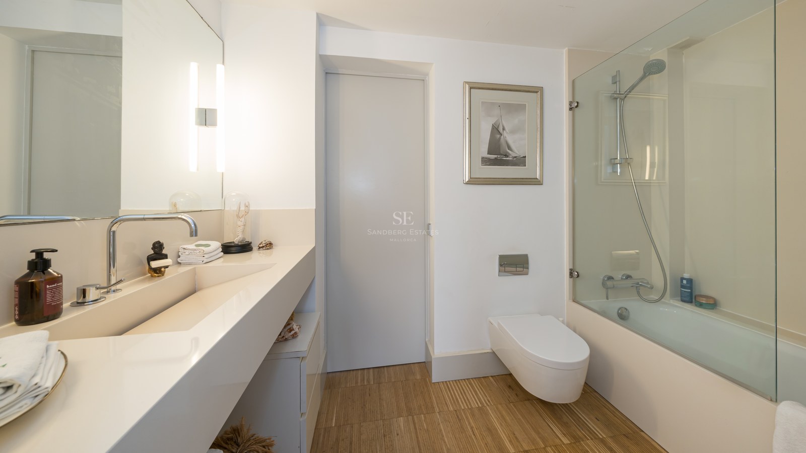 Modernes Badezimmer mit integriertem Waschtisch, wandhängendem WC und Badewanne mit Glastrennwand.