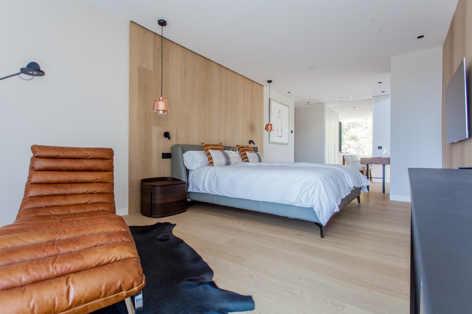 Zeitgenössisches Schlafzimmer mit Eichenwand, Leder-Chaiselongue und Kupfer-Pendelleuchten.