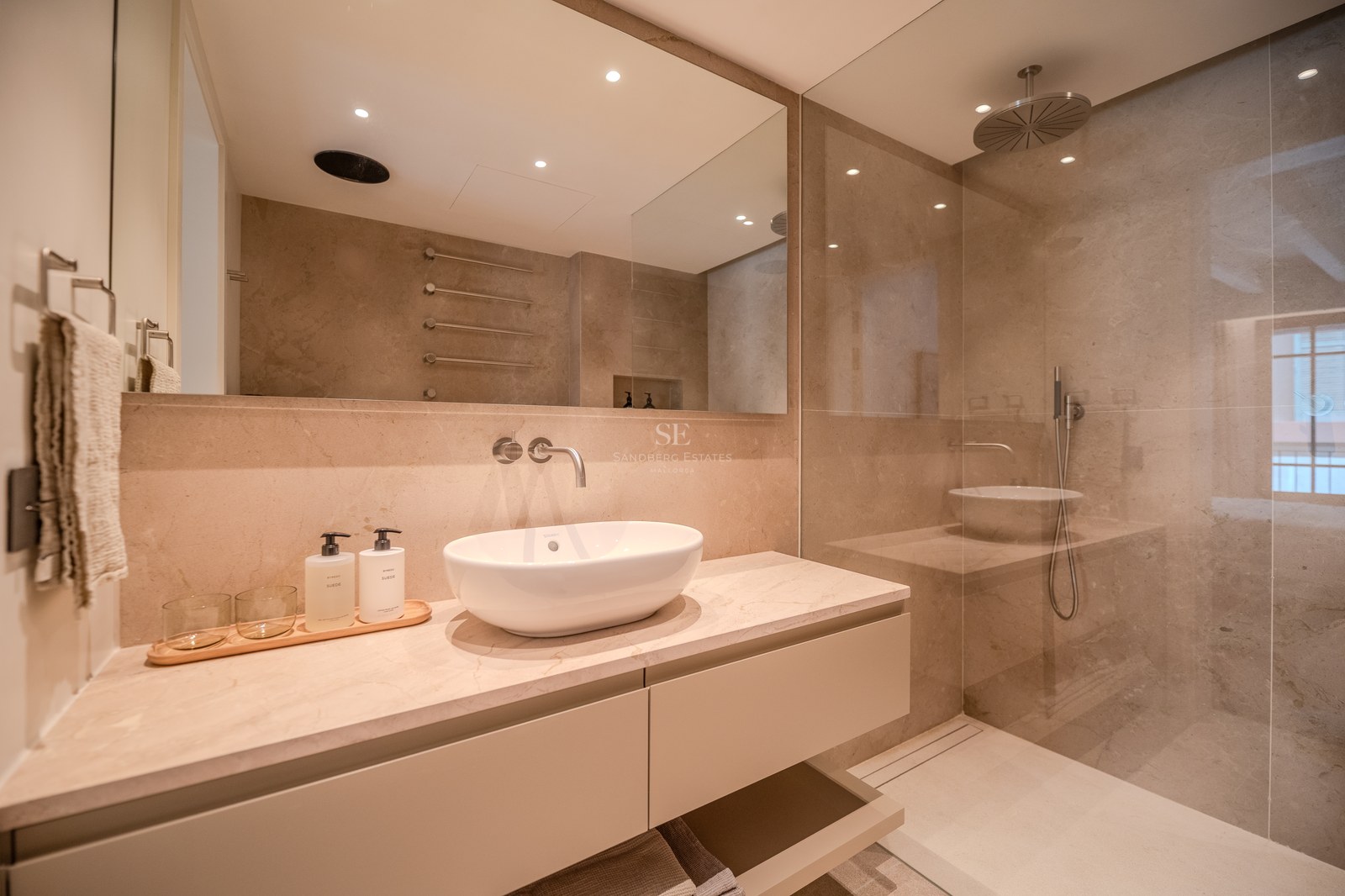 Salle de bain moderne avec vasque à poser, plan de travail en marbre et douche à l'italienne vitrée.