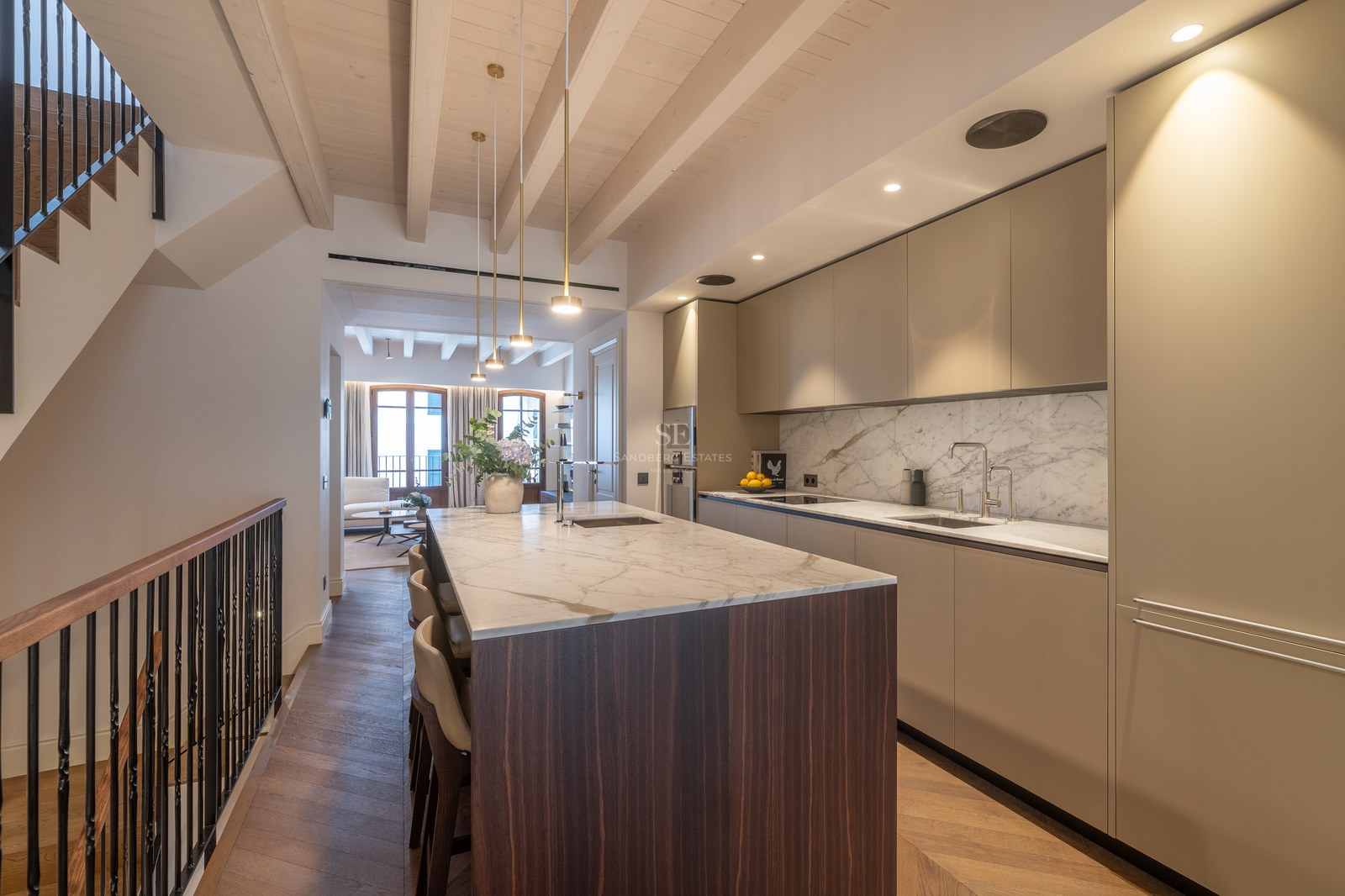 Cuisine moderne avec îlot central en marbre, parquet en chêne à bâtons rompus et poutres apparentes.