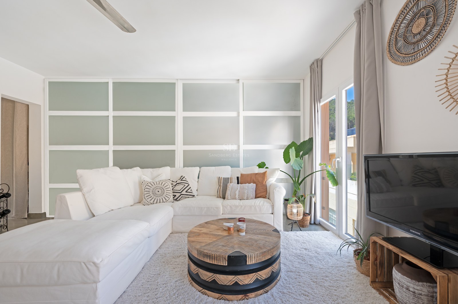 Modernes Wohnzimmer mit weißem Ecksofa, geschnitztem Holztisch und Trennwänden aus Milchglas.