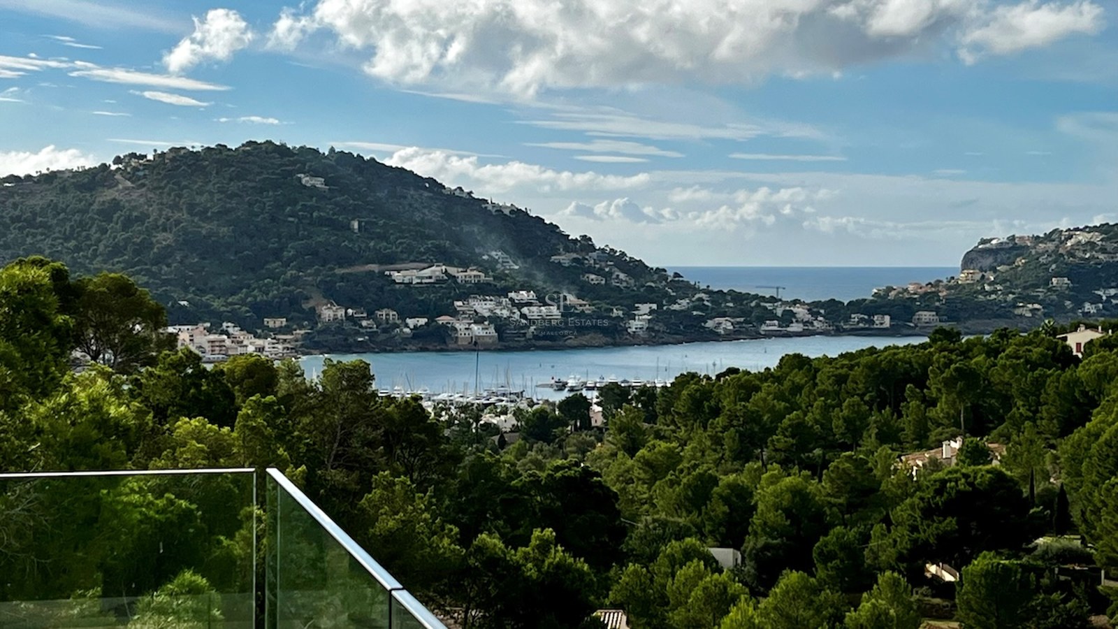Vista panorámica de una moderna piscina infinita con tumbonas y vistas al mar. Diseño elegante y minimalista. Cielo azul y arquitectura contemporánea.