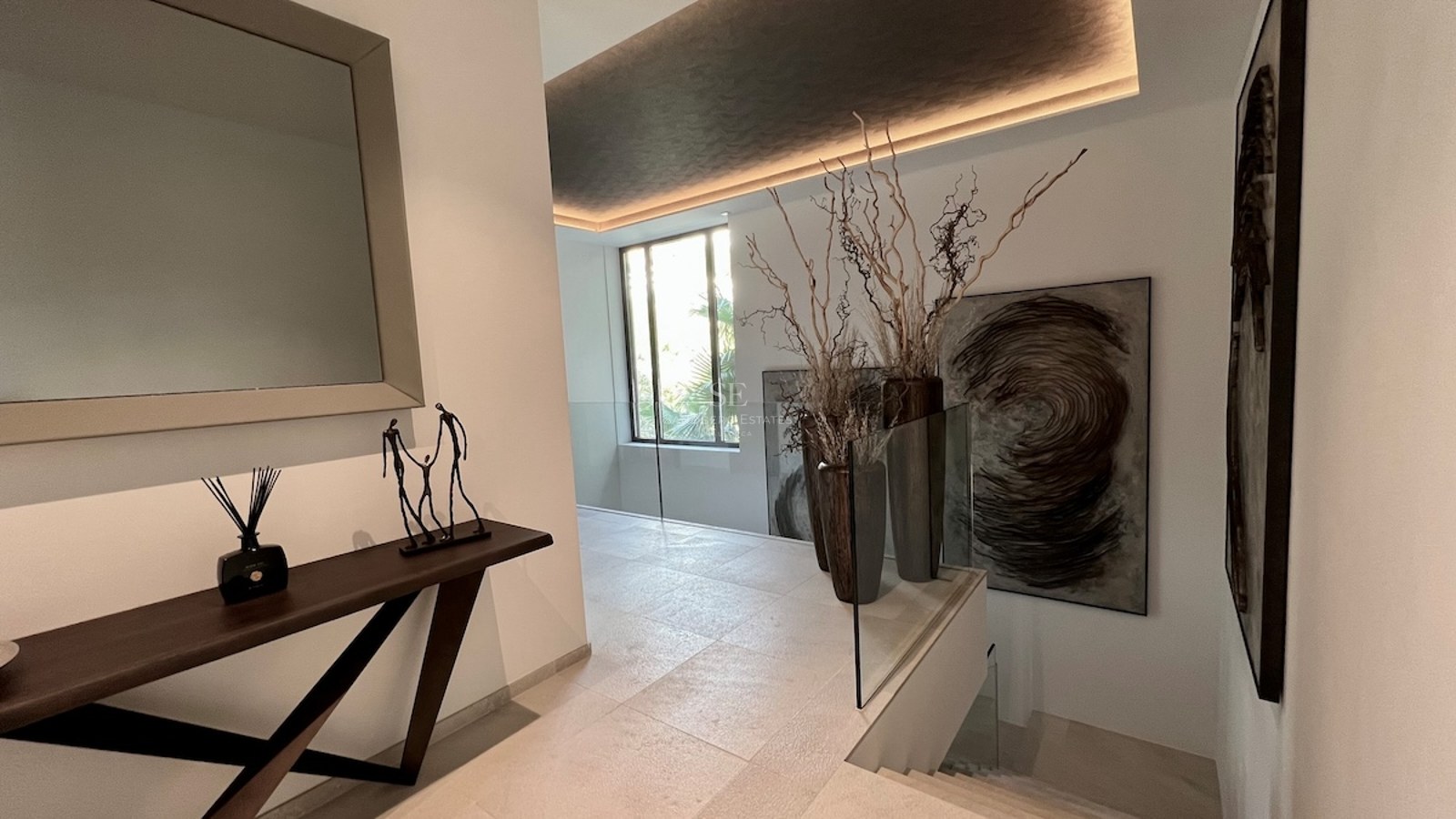 Vista exterior de una casa moderna con piscina, jardín bien cuidado, fachada blanca y amplios ventanales que ofrecen mucha luz natural.