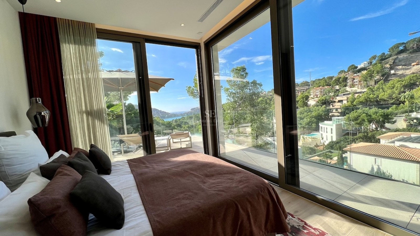 Amplia terraza con piscina rodeada de vegetación exuberante. Diseño moderno con mobiliario elegante y vistas panorámicas.