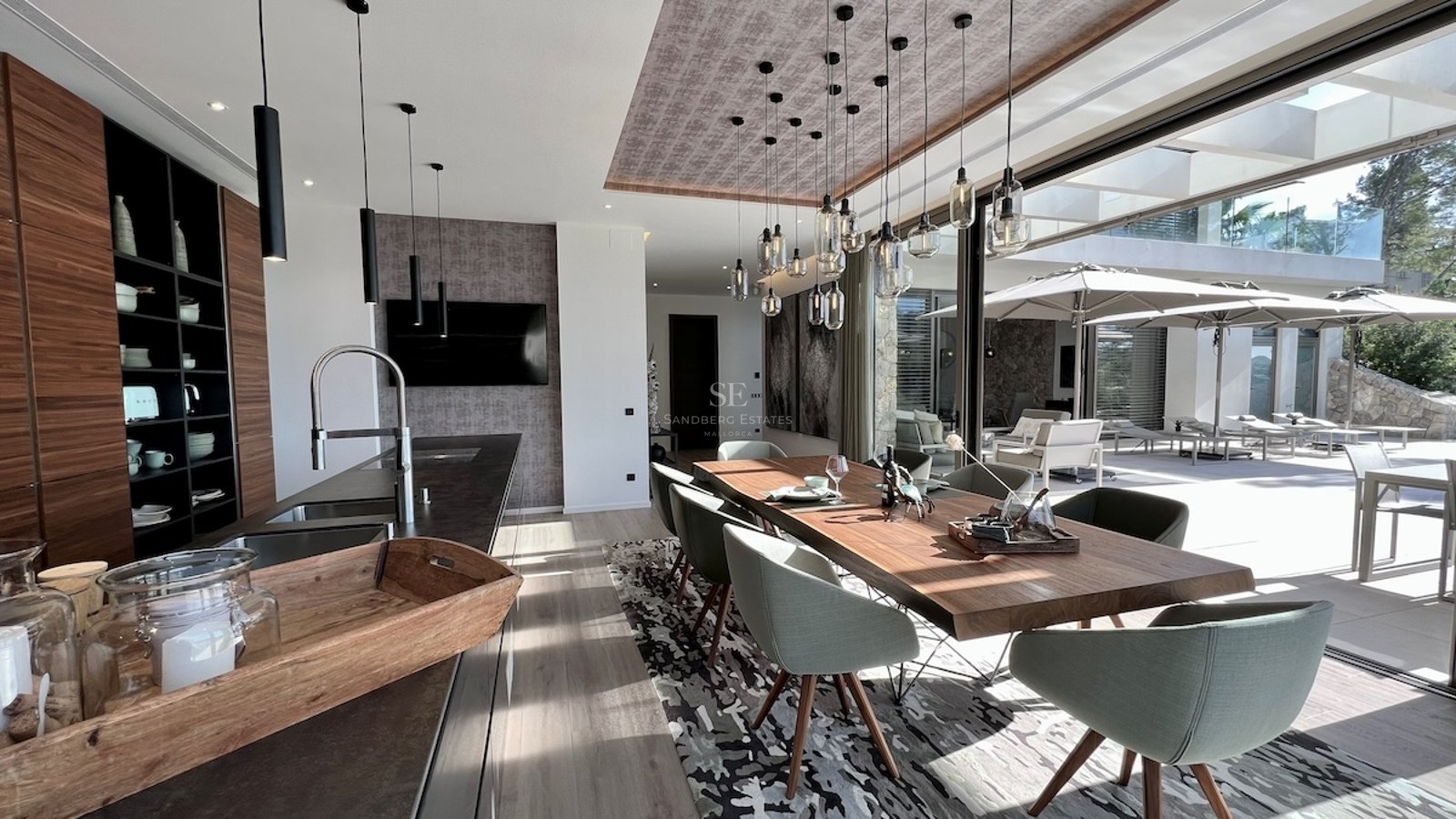 Ático moderno con balcón acristalado, vistas al mar y diseño minimalista. Iluminación natural y paleta de colores neutros.
