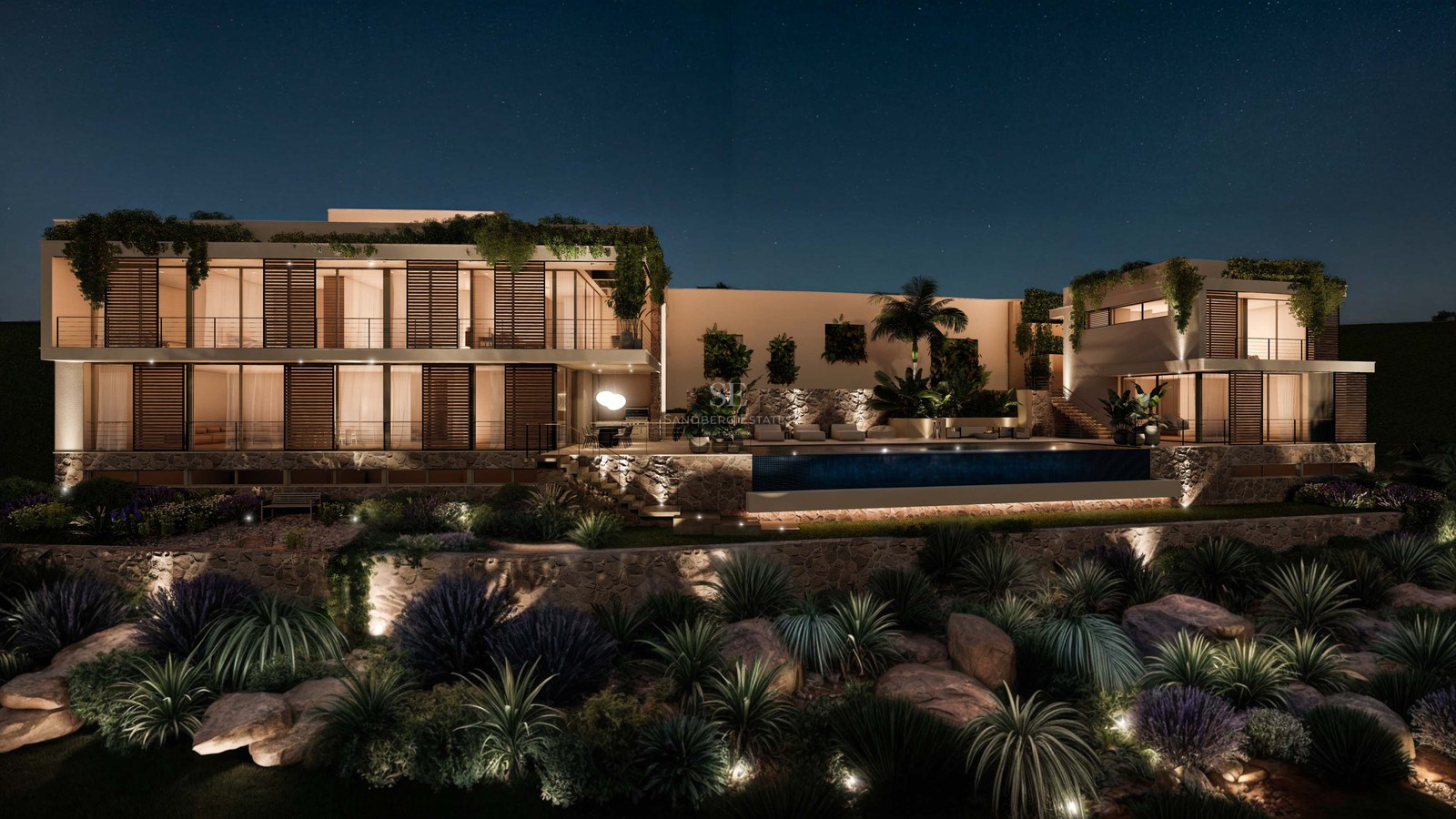Vue nocturne d'une villa de luxe avec piscine éclairée, murs en pierre naturelle et baies vitrées.