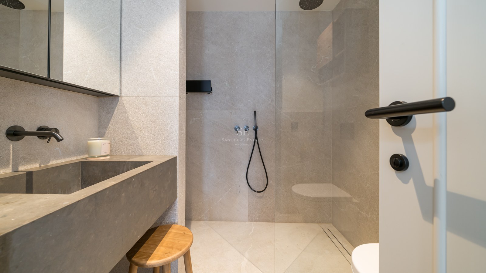 Contemporary bathroom featuring a grey stone washbasin, black matte faucets, and a glass-enclosed walk-in shower.