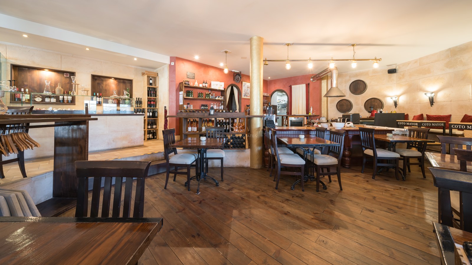 Amplia bodega de estilo rústico con suelos de madera oscura, paredes de piedra natural y zona de bar integrada.