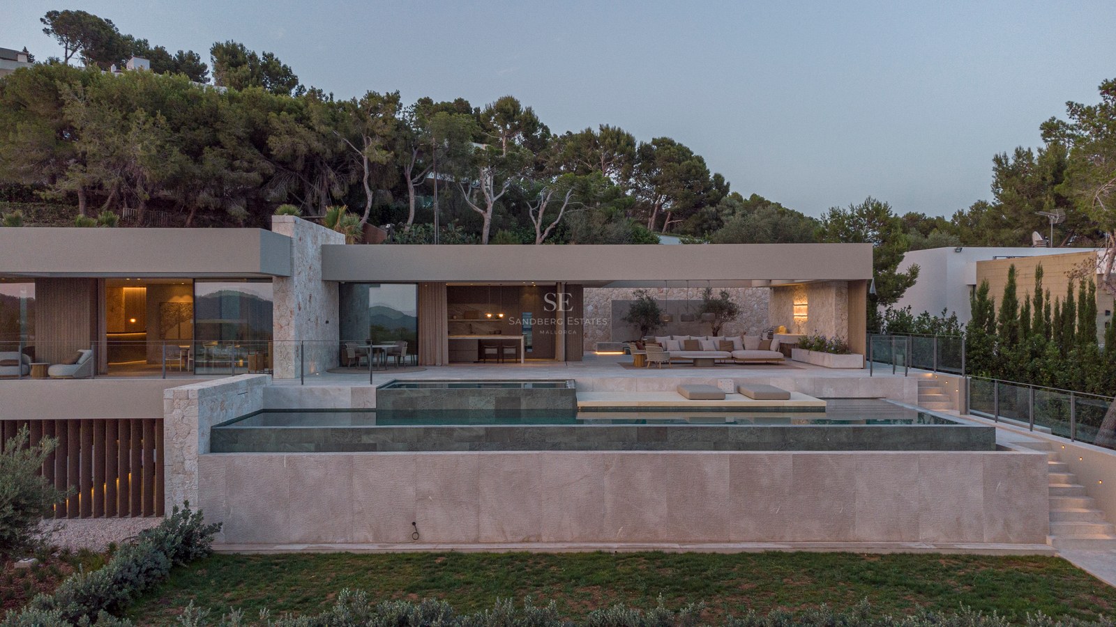 Vue extérieure d'une villa contemporaine avec piscine à débordement multi-niveaux et salon d'été au crépuscule.