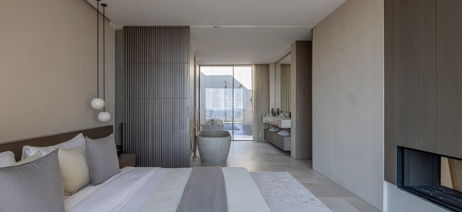 Chambre moderne avec baignoire en pierre îlot, panneaux en bois et baies vitrées toute hauteur.