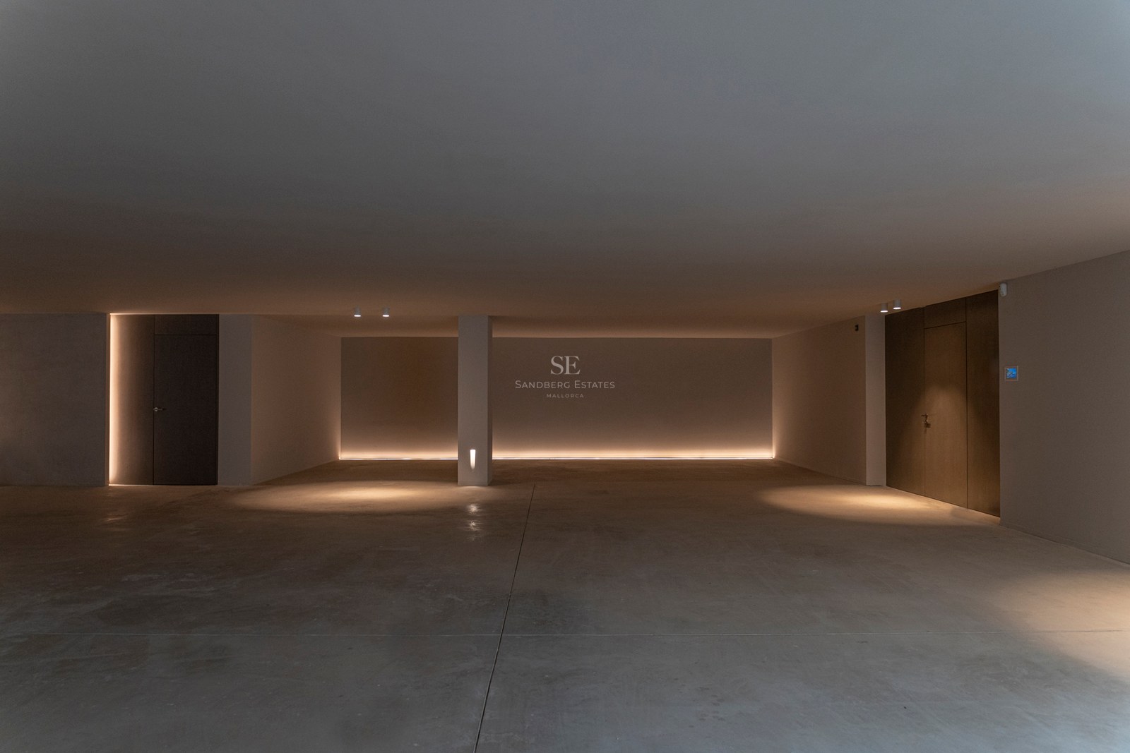 Vue large d'un garage souterrain minimaliste avec sol en béton poli et éclairage LED indirect chaleureux.