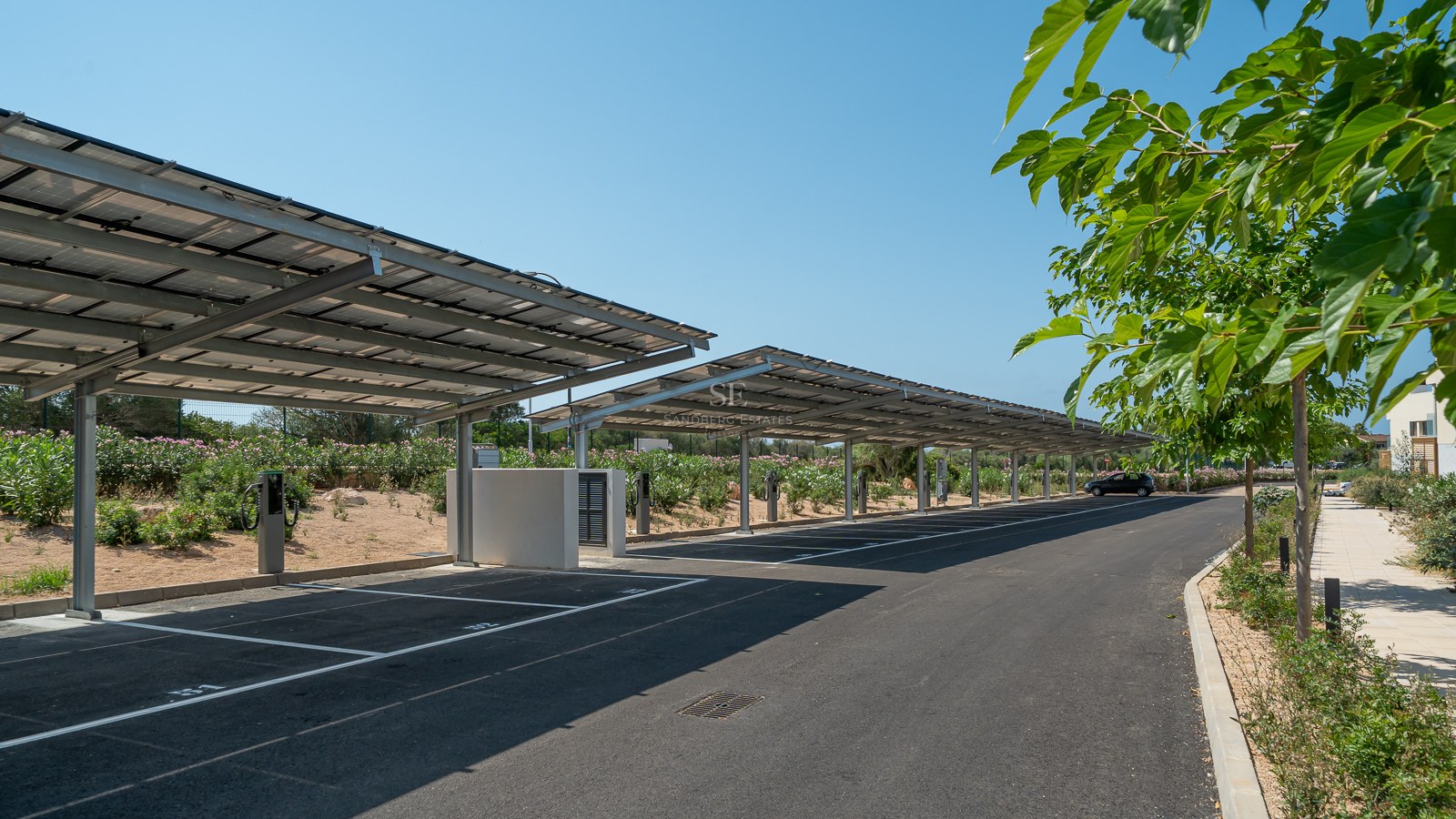 Modern outdoor parking area featuring solar panel carports and integrated electric vehicle charging points.