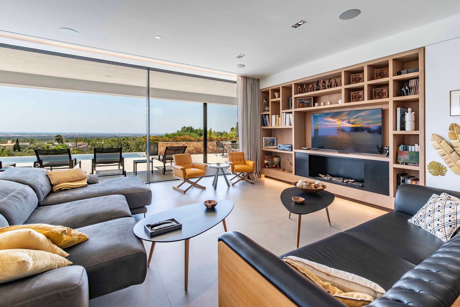 Contemporary living room featuring floor-to-ceiling glass doors, infinity pool access, and expansive coastal views.
