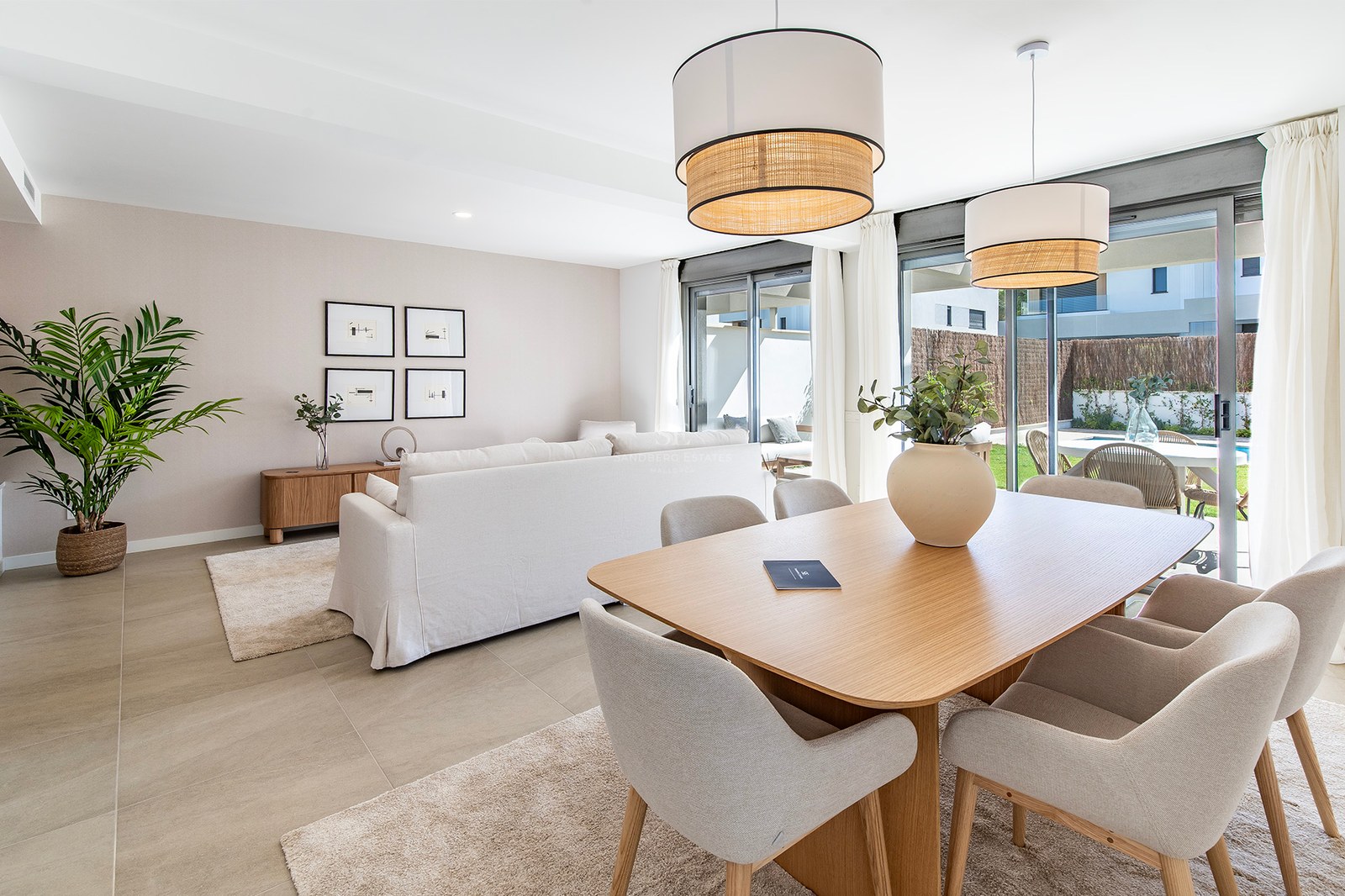 Salón-comedor contemporáneo de tonos neutros con muebles de roble y acceso directo a una terraza soleada.