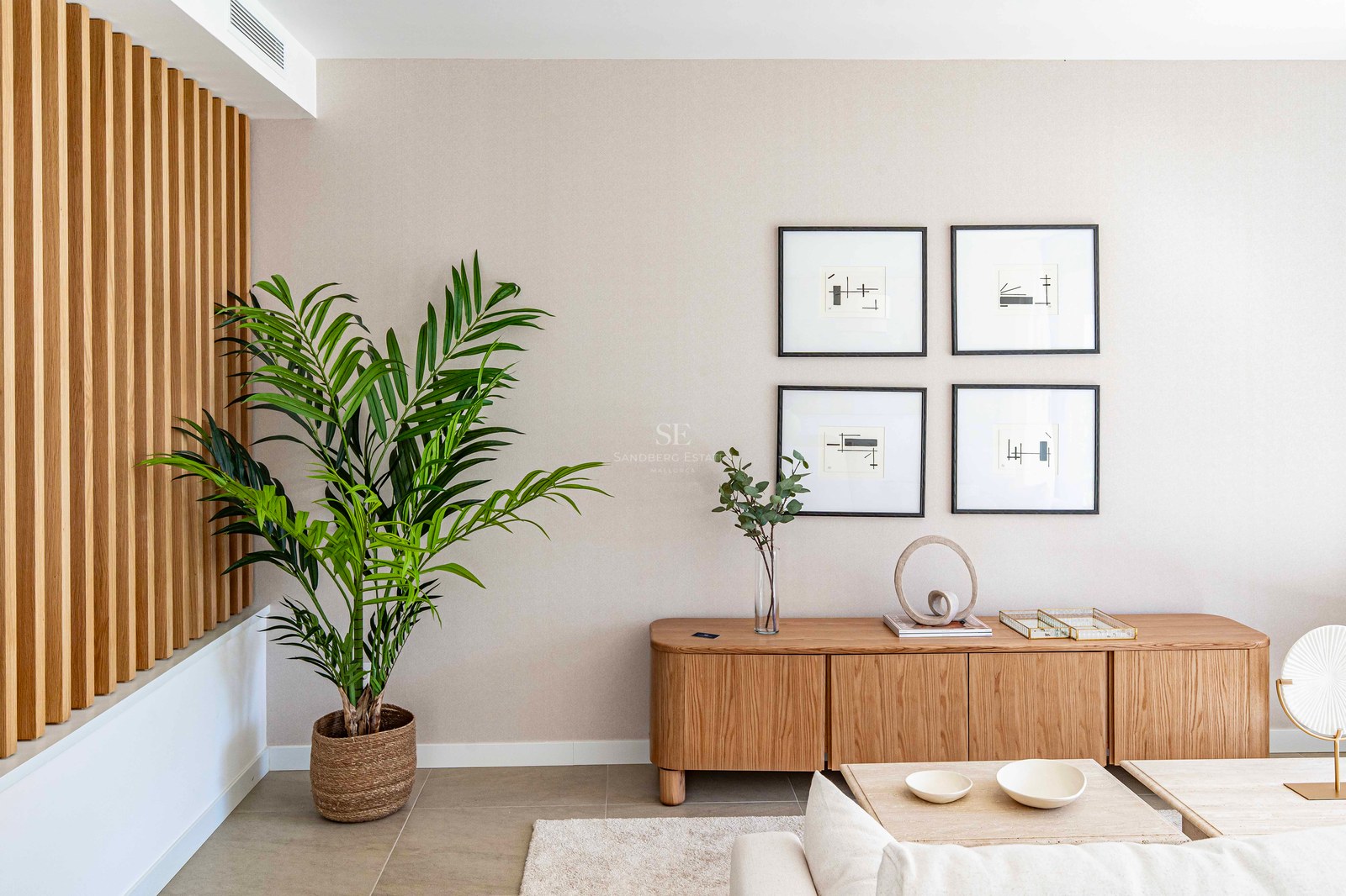 Modernes Wohnzimmer mit Eichen-Sideboard, Holzlamellen, minimalistischer Kunst und üppiger Zimmerpflanze.