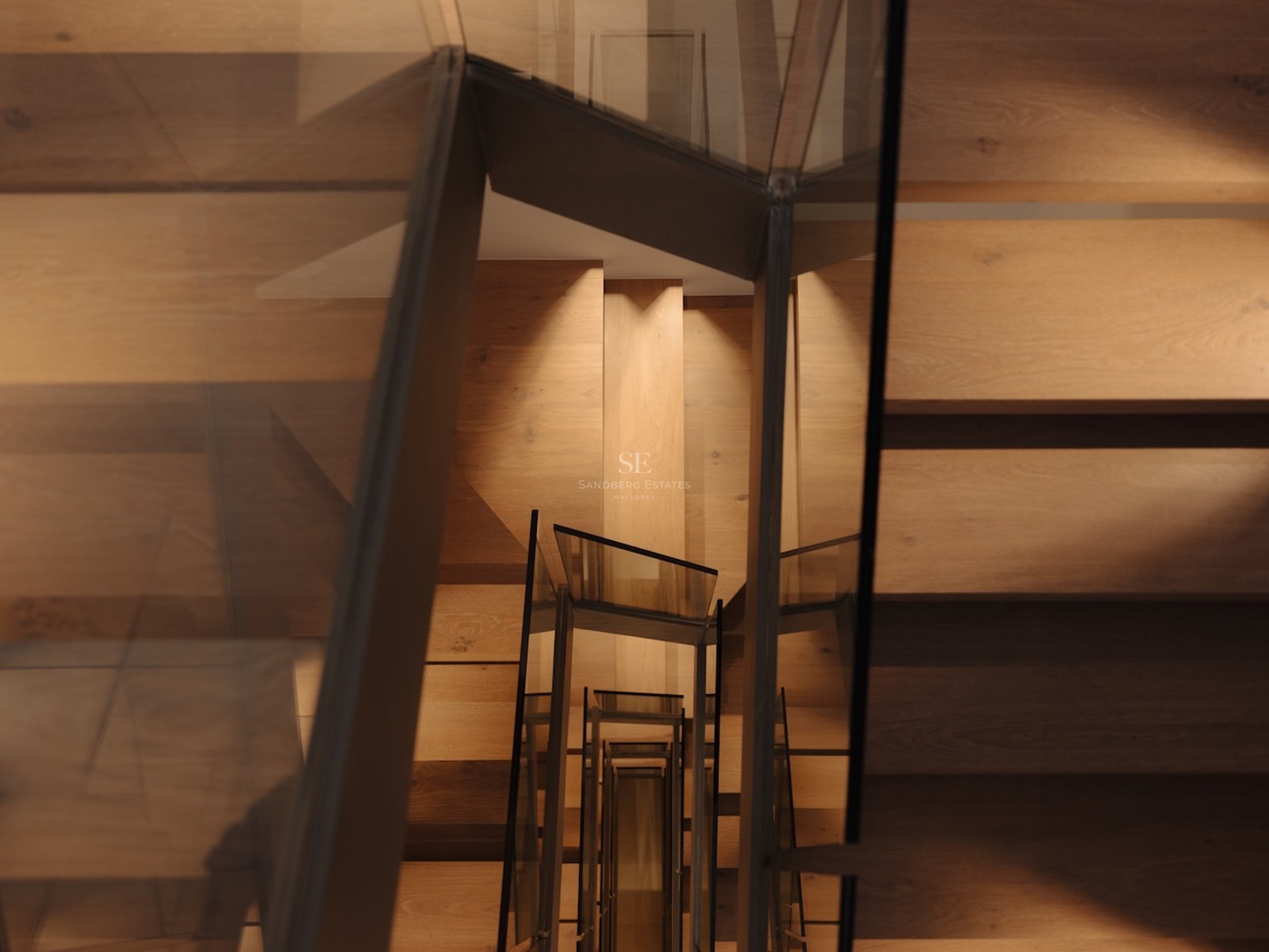Vista cenital de una escalera moderna de madera con barandillas de vidrio e iluminación integrada cálida.