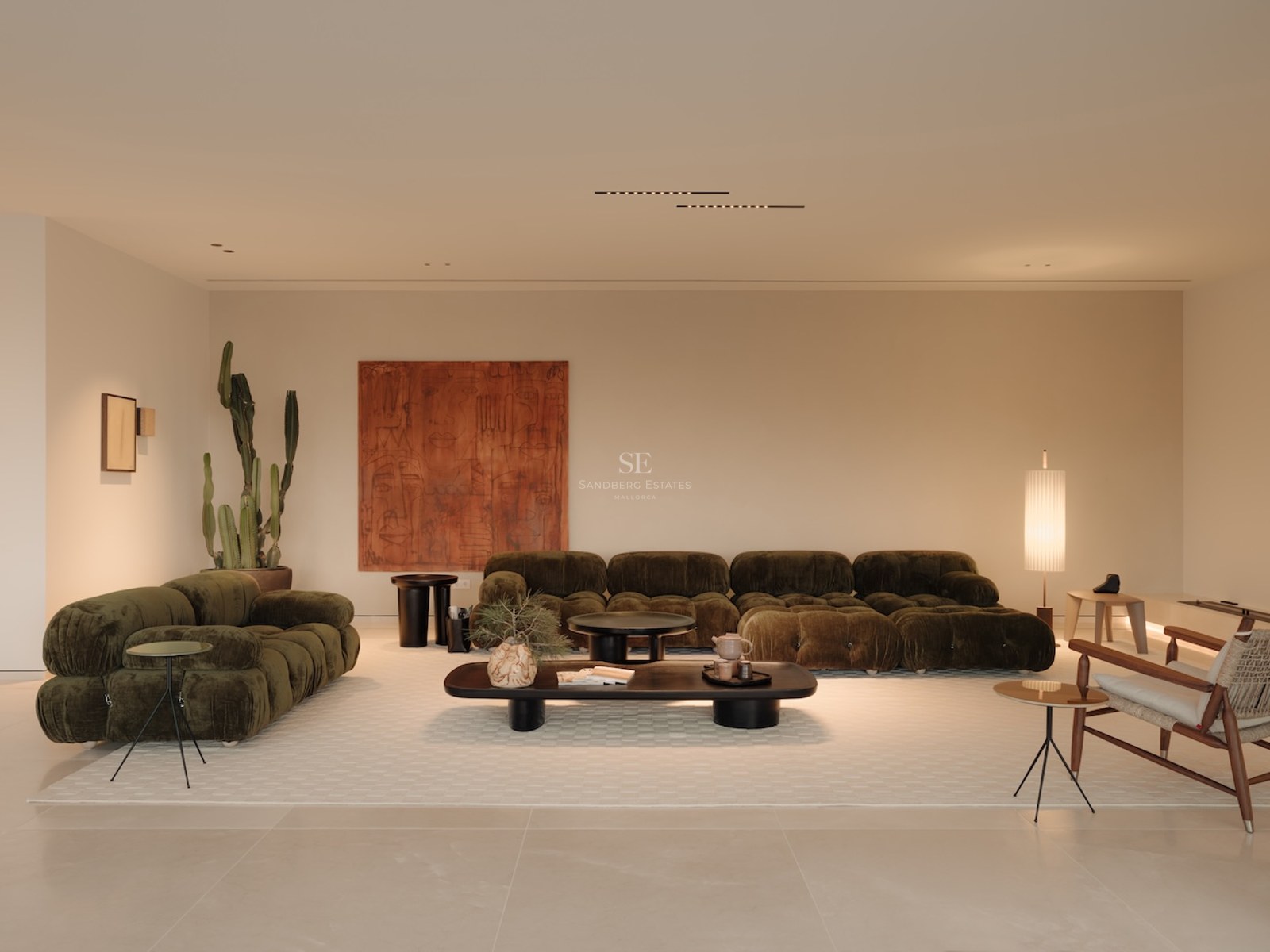 Salón moderno con sofás modulares verde oliva, un gran cuadro terracota y decoración minimalista sobre suelo claro.