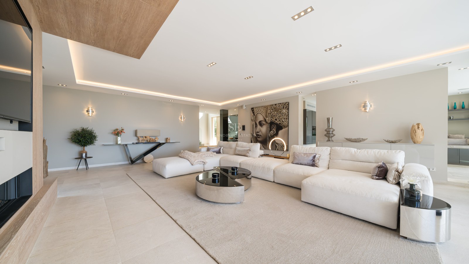 Large white modular sofa in a modern open-plan living room with porcelain flooring and warm LED lighting.
