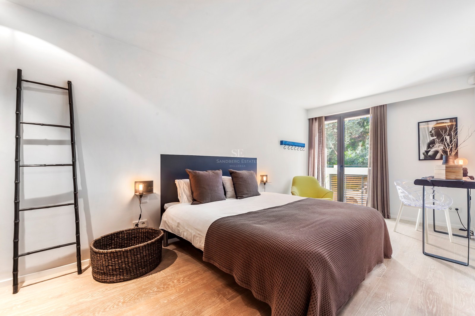Chambre contemporaine avec lit double, parquet clair et porte vitrée ouvrant sur une terrasse.