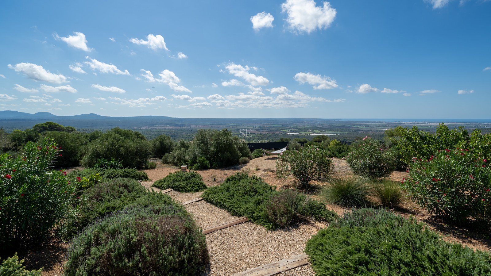 Vista exterior de una moderna casa con piscina infinita, rodeada de vegetación. Arquitectura minimalista, cristaleras y detalles de diseño.