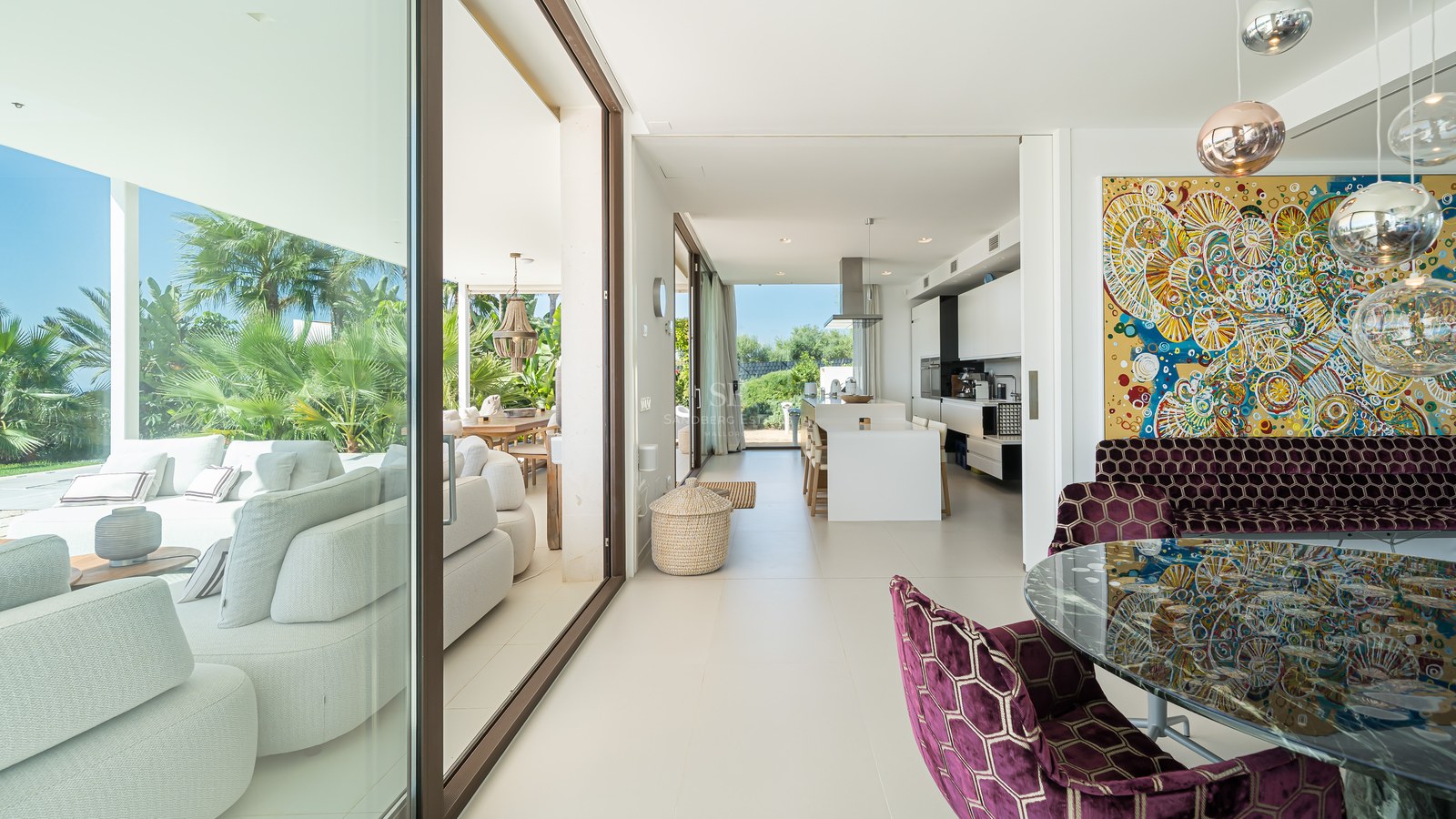 Amplia terraza con piscina infinita y vistas al mar. Diseño moderno, elegante mobiliario y exuberante vegetación.