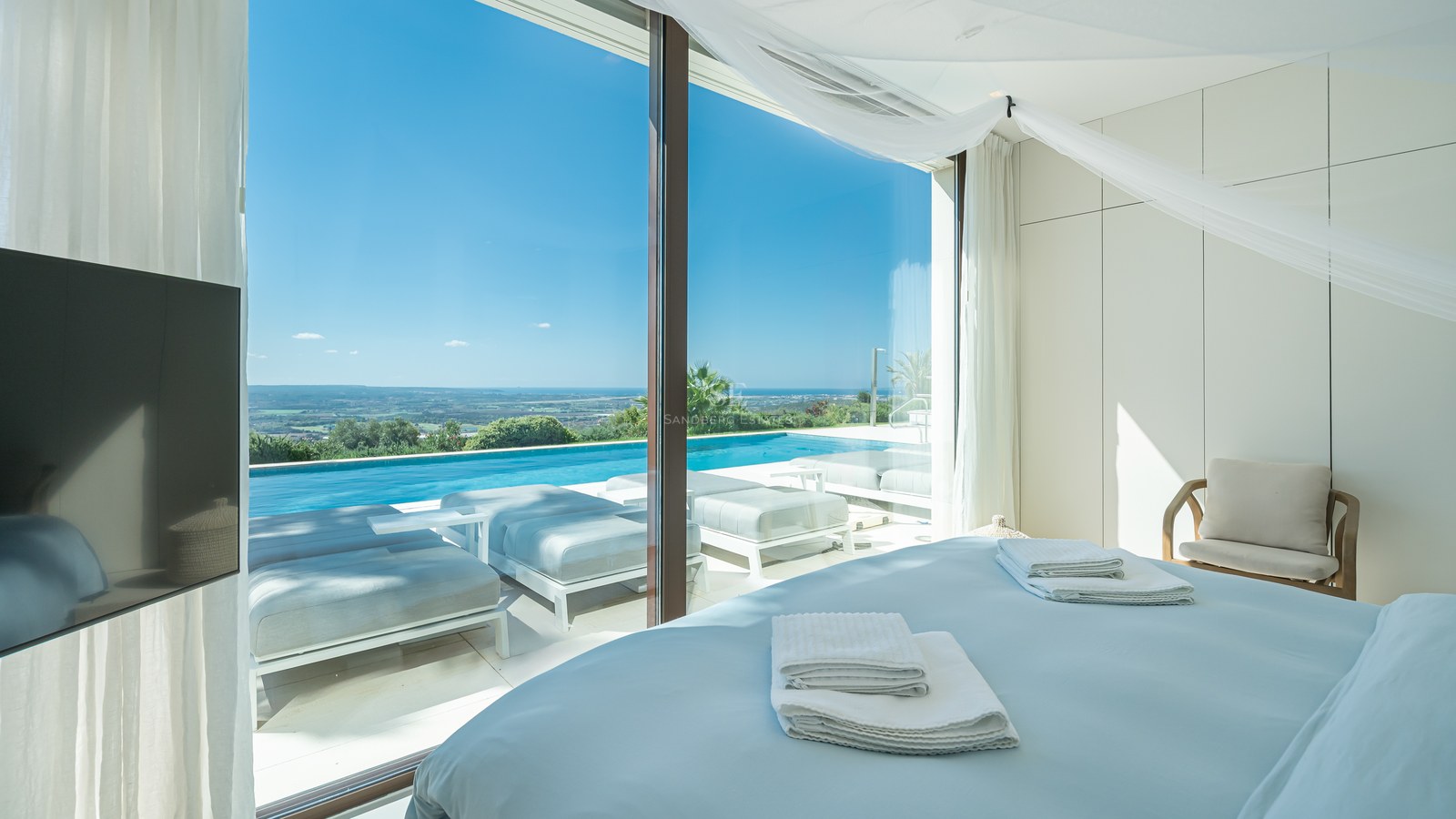 Vista exterior de villa moderna con piscina infinita, amplios ventanales y jardín exuberante. Arquitectura contemporánea y diseño elegante.
