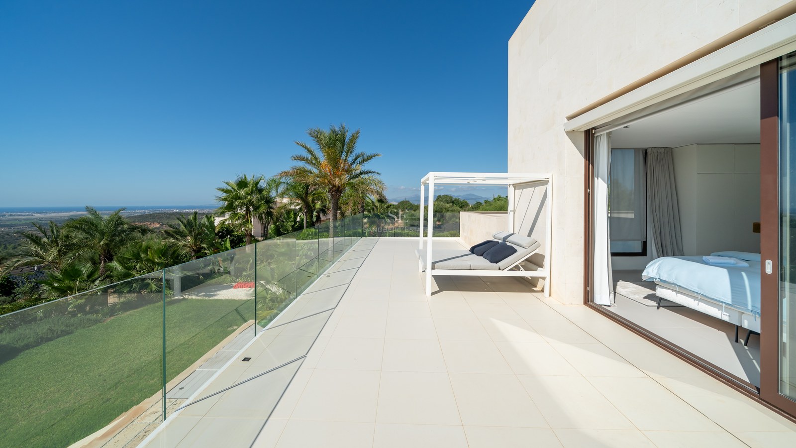 Vista exterior de una villa moderna con piscina, amplias cristaleras y exuberante jardín. Diseño minimalista y acabados de alta calidad.