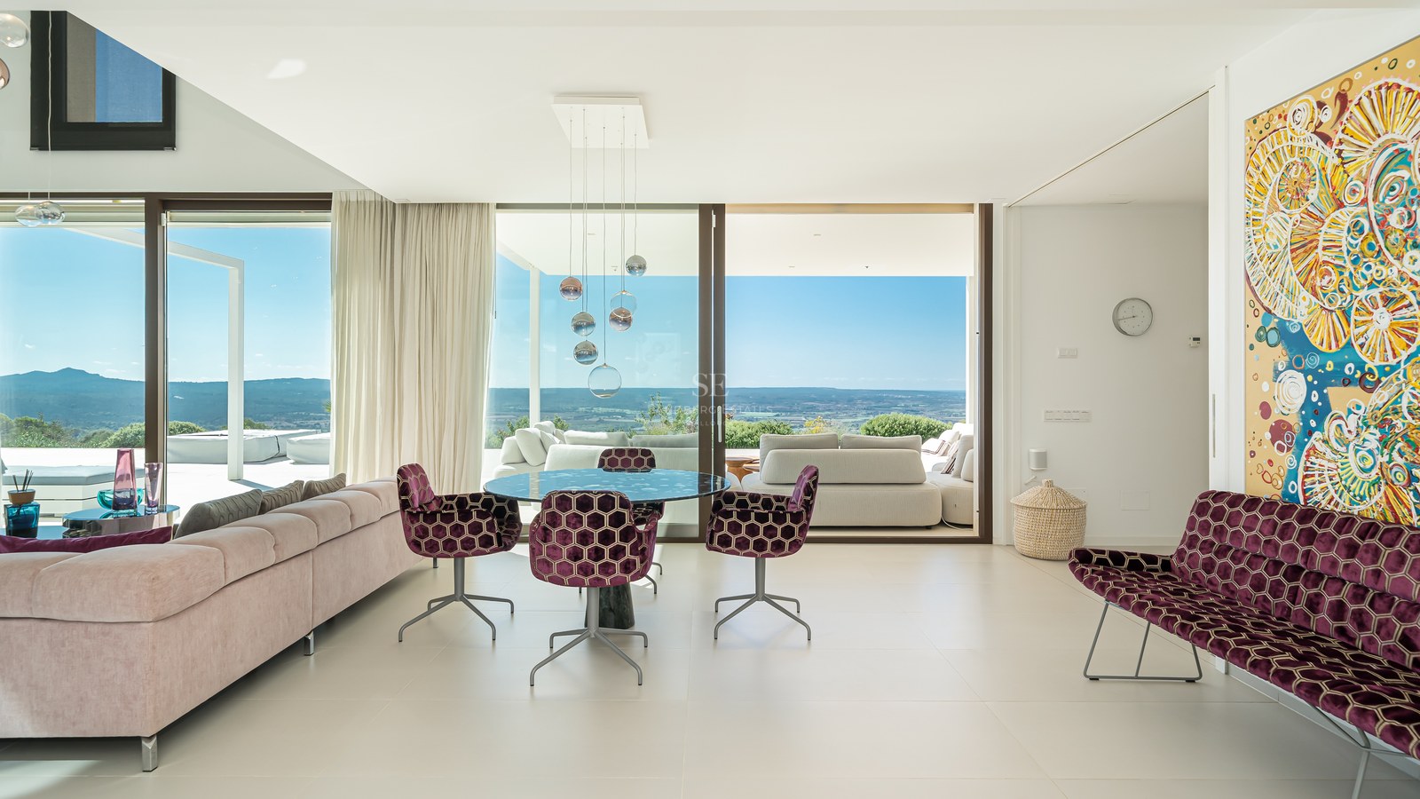 Vista exterior de una villa moderna con piscina infinita, tumbonas y exuberante jardín. Arquitectura minimalista con amplias ventanas.