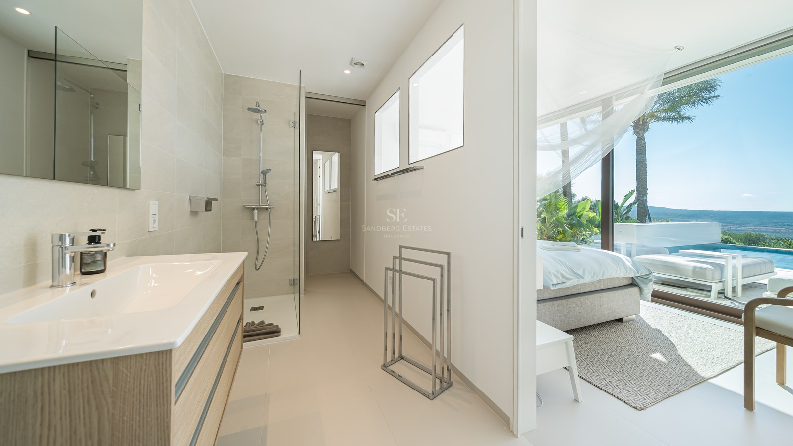 Balcón moderno con barandilla de cristal, vistas impresionantes, muebles de exterior elegantes y suelo de madera. Diseño minimalista y luminoso.