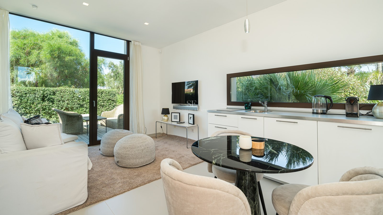 Amplia terraza con piscina infinita, tumbonas y vistas panorámicas al mar. Diseño moderno con líneas limpias y vegetación exuberante.