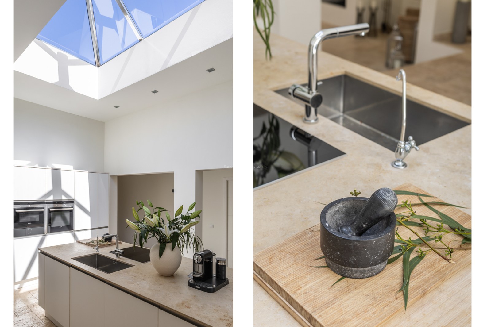 Îlot de cuisine avec plan de travail en pierre naturelle sous un grand puits de lumière en verre et appareils intégrés.
