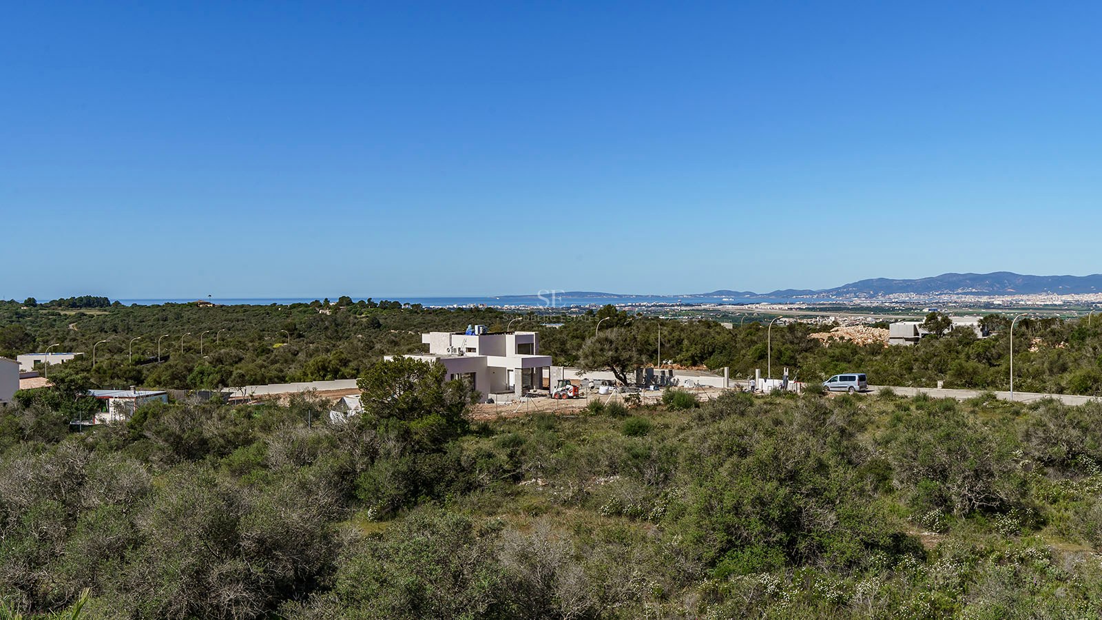 Vue extérieure d'une villa contemporaine blanche en construction surplombant la côte méditerranéenne.