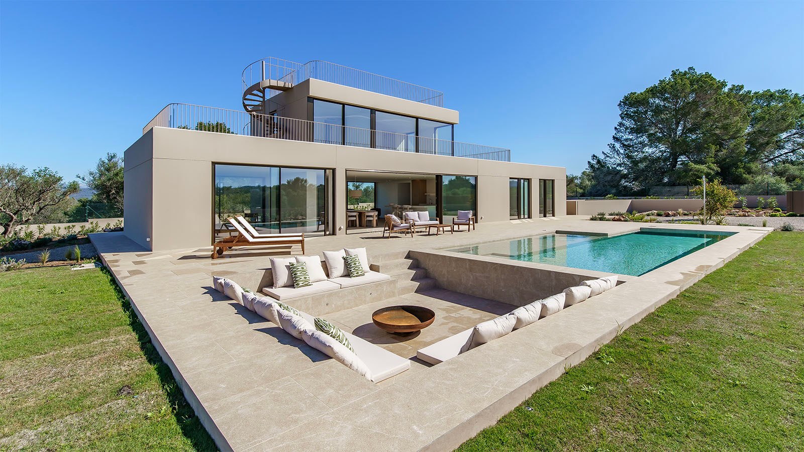 Villa moderne de deux étages avec façade couleur sable, piscine et salon de jardin encastré avec brasero.