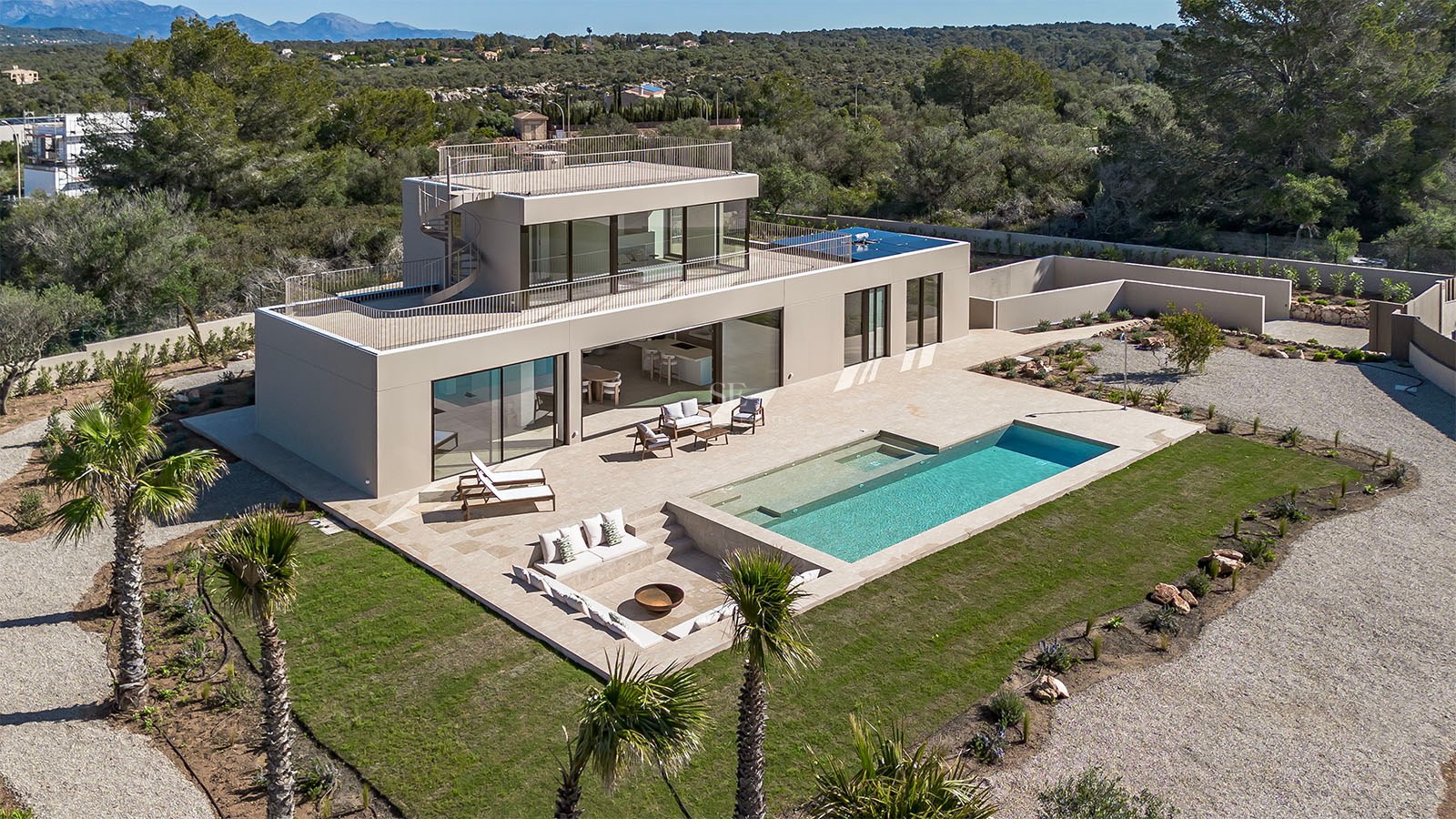 Vue aérienne d'une villa moderne avec piscine, terrasse et salon extérieur encastré.
