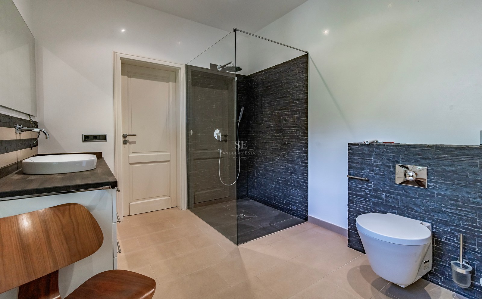 Salle de bain contemporaine avec douche à l'italienne en verre, murs en ardoise, WC suspendu et vasque à poser.