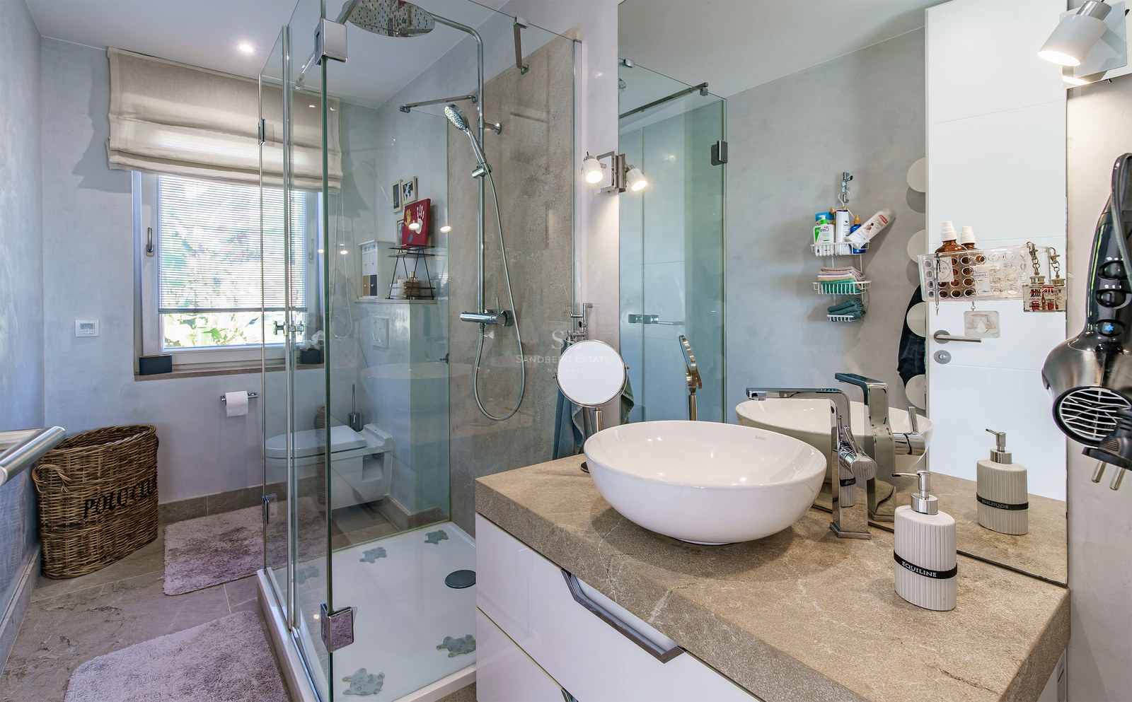 Baño contemporáneo con cabina de ducha de cristal, encimera de piedra natural y lavabo de diseño.