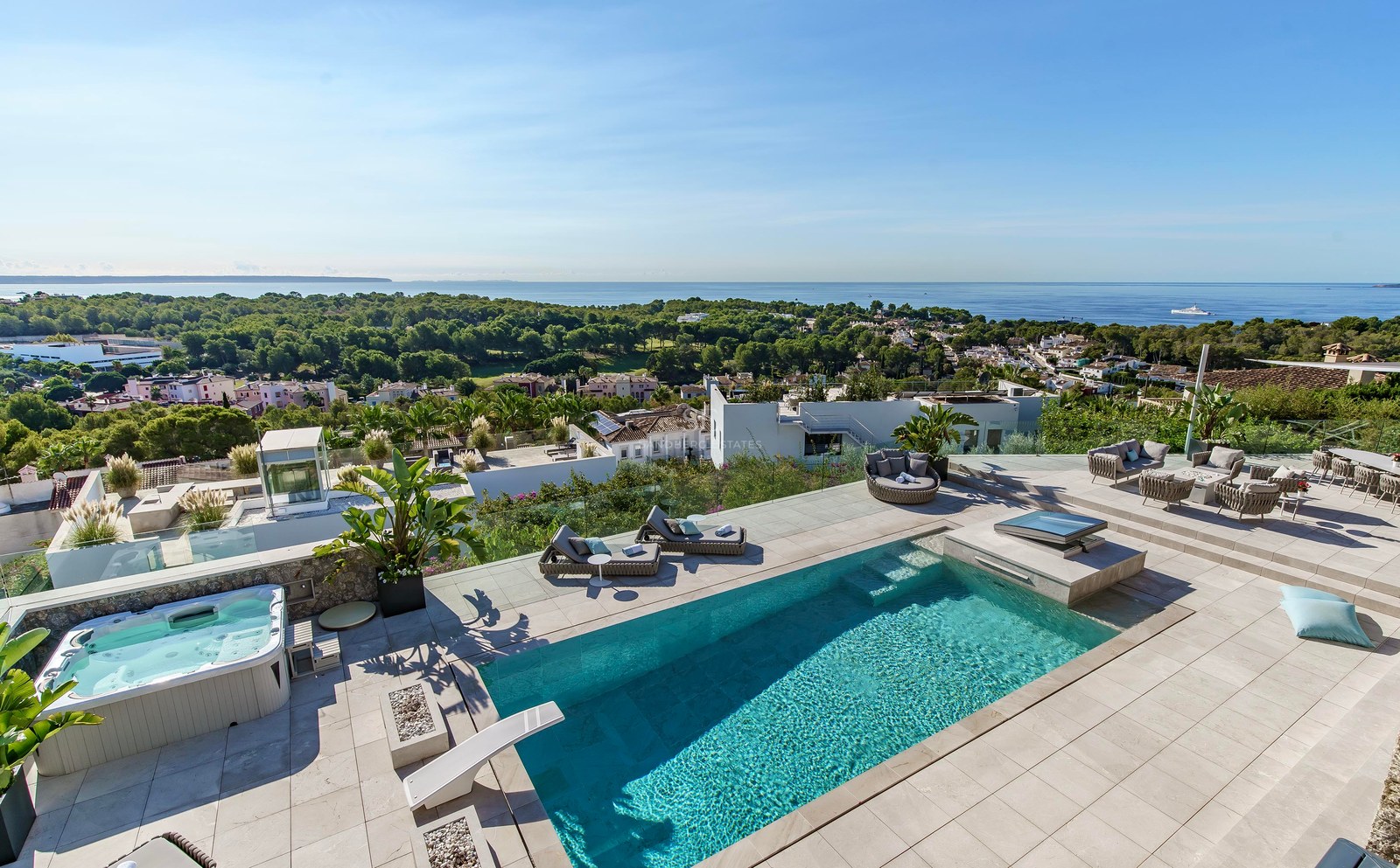 Terraza elevada con piscina turquesa, jacuzzi exterior y zona lounge con vistas panorámicas al Mediterráneo.