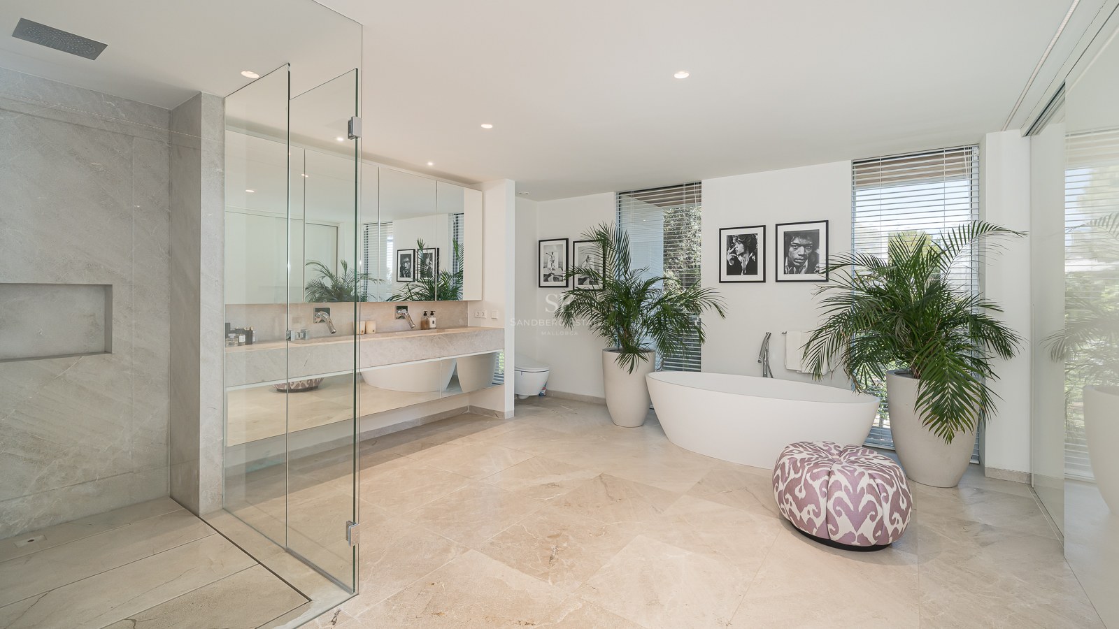 Spacious master bathroom featuring a freestanding tub, glass walk-in shower, marble floors, and double vanity.