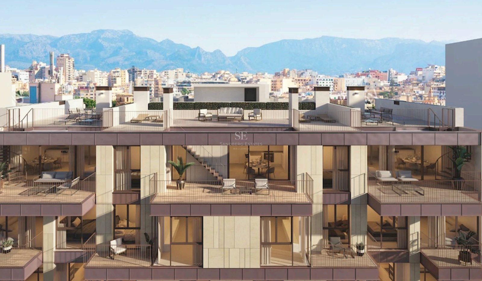 Modern building facade featuring multiple balconies, rooftop terraces, and a backdrop of city and mountains.