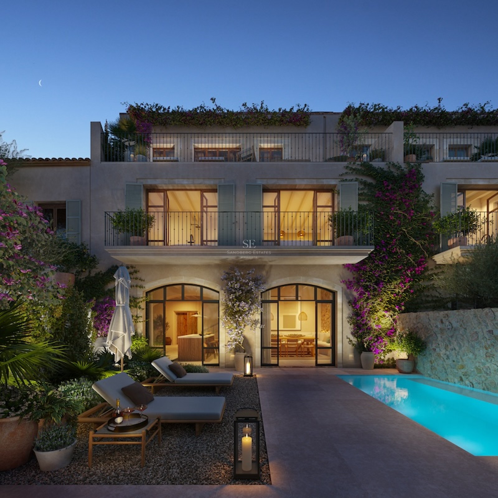 Luxury outdoor patio with a glowing blue pool, sun loungers, stone walls, and a Mediterranean villa at night.