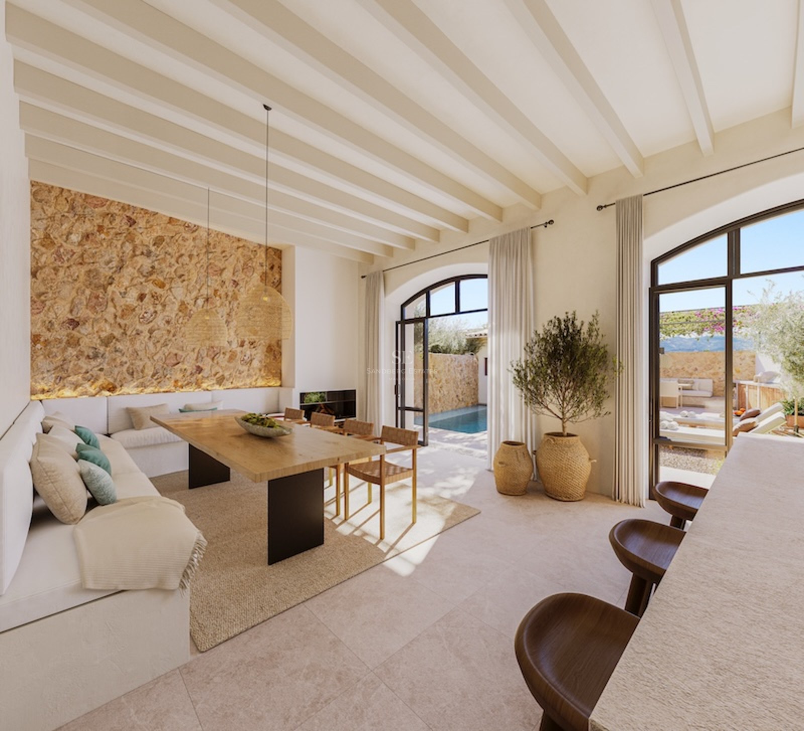 Modern Mediterranean dining room with stone wall, wooden table, and arched doors opening to a pool area.