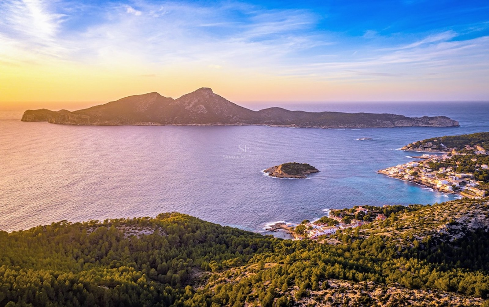 Vista aérea del mar Mediterráneo y la isla Dragonera al atardecer con luces doradas sobre la costa.