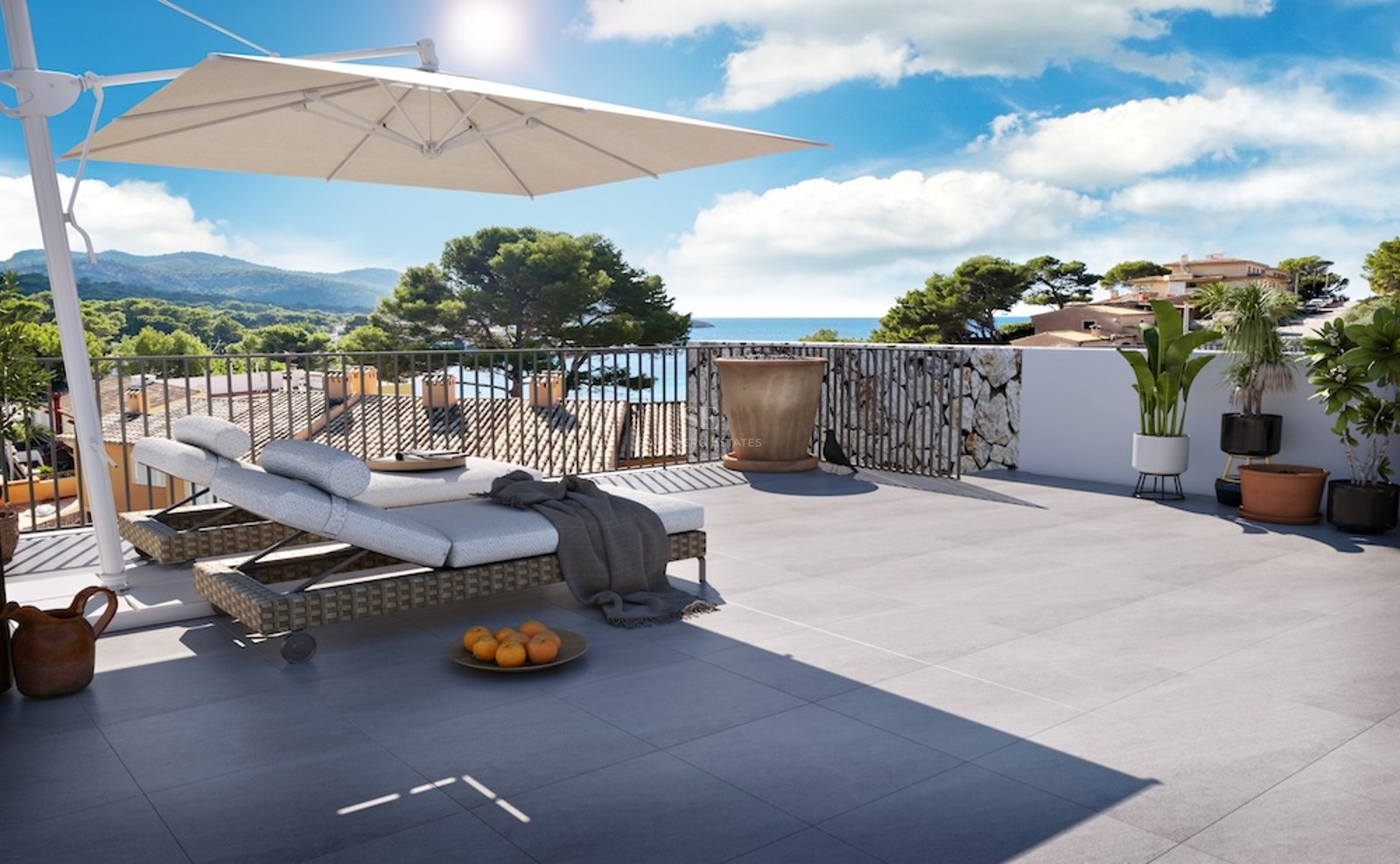 Terraza soleada con tumbonas, sombrilla grande y vistas panorámicas al mar y la montaña.